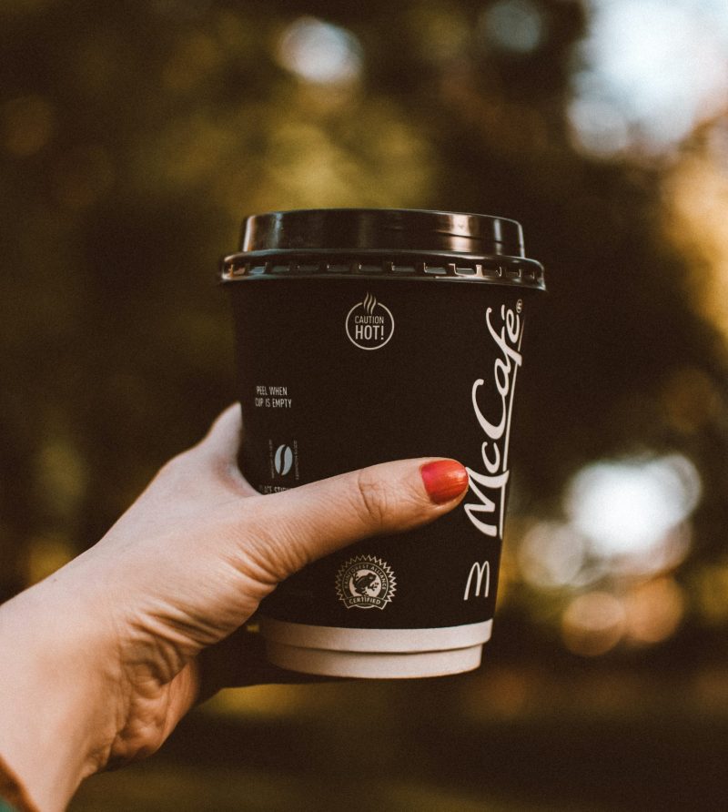 selective-focus-photo-of-woman-s-hand-holding-out-a-mccafe-3138487